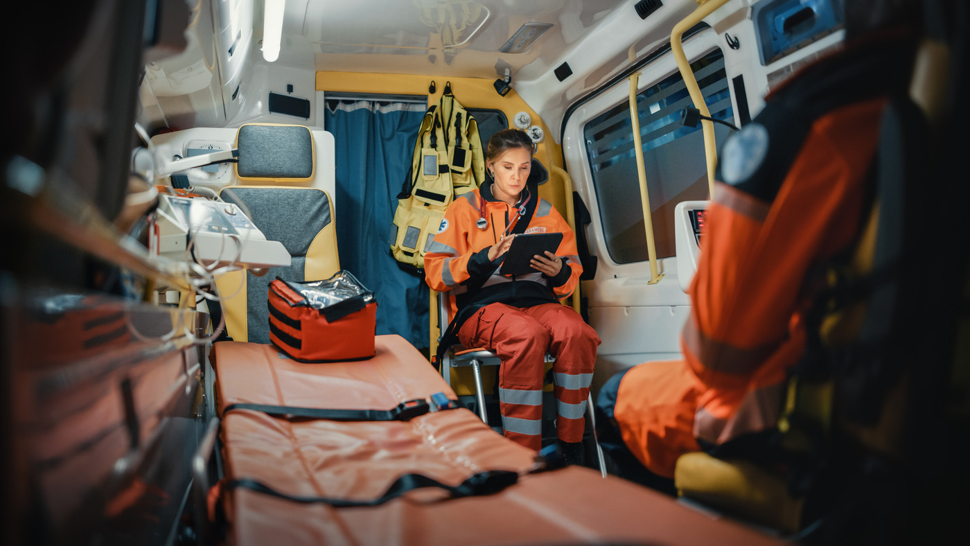 Female ambulance officer using tablet in van