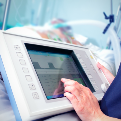 Closeup of nurse using connected device at patient bedside