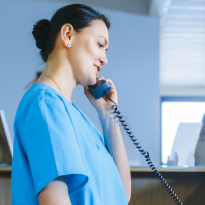 Nurse using landline in busy hospital