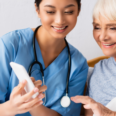 Nurse and older patient looking at mobile phone (Ascom and AnglicareSA logos)