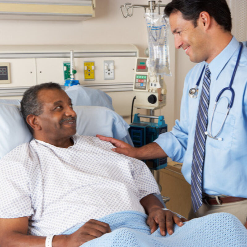 Doctor with elderly patient in bed