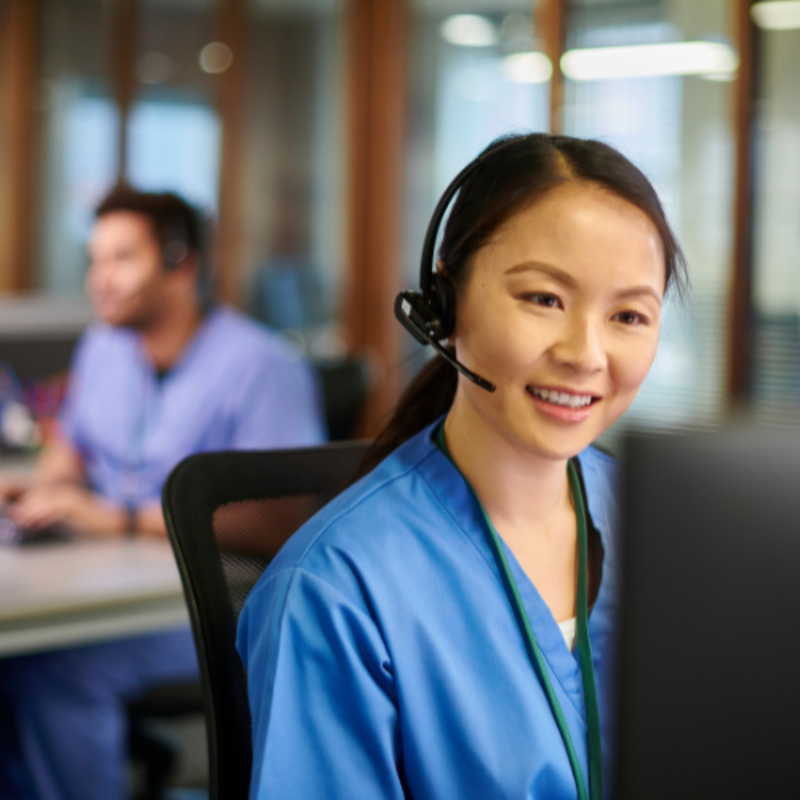 Nurse at computer using telephone headset