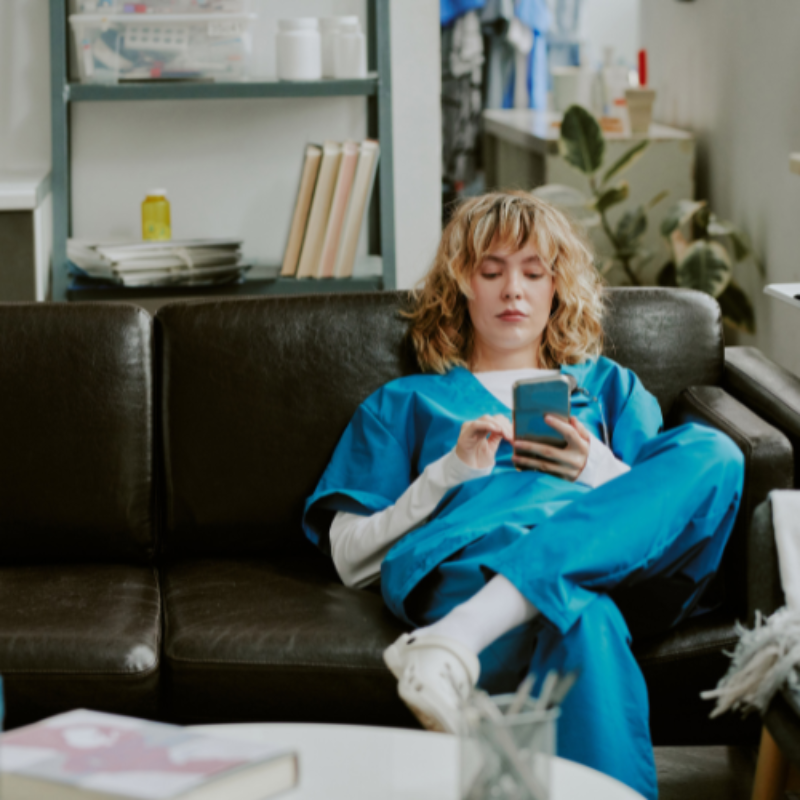 Nurse using mobile phone on couch in break room