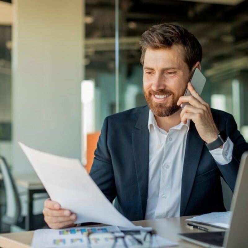 Office worker on mobile phone reviewing document